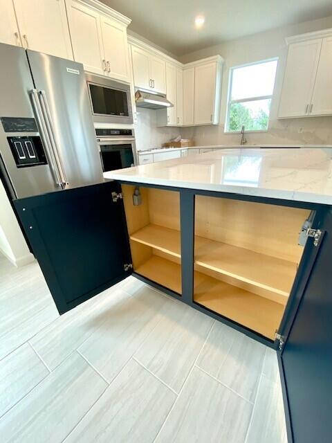 1375 Haven Circle Vero Beach, FL 32960 - Photo 16 of 36 a kitchen with stainless steel appliances a refrigerator a sink a stove a microwave and cabinets