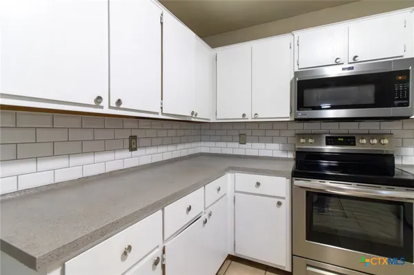 a kitchen with appliances a sink and cabinets