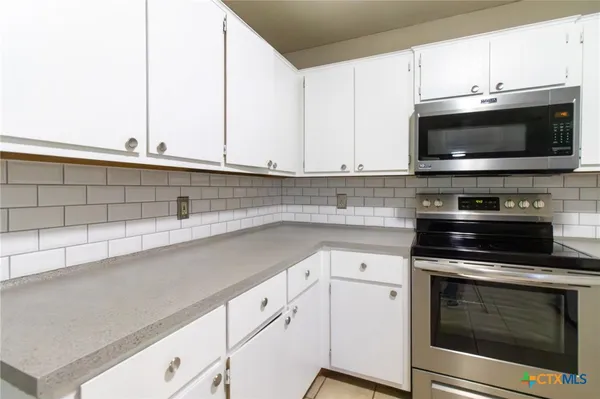 a kitchen with stainless steel appliances a stove microwave and sink