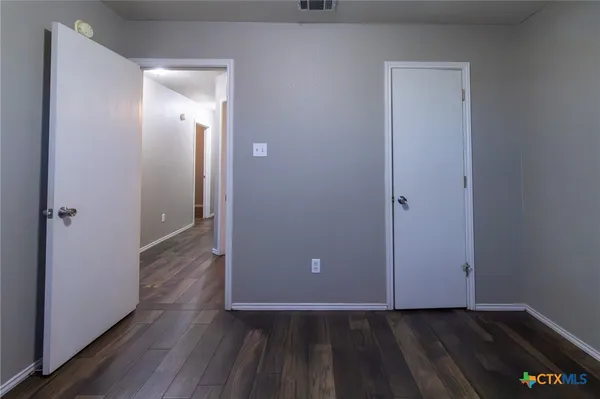 an empty room with wooden floor and closet