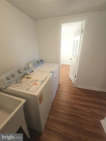 a utility room with wooden floor washer and dryer