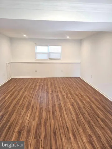 a view of a room with wooden floor and white walls