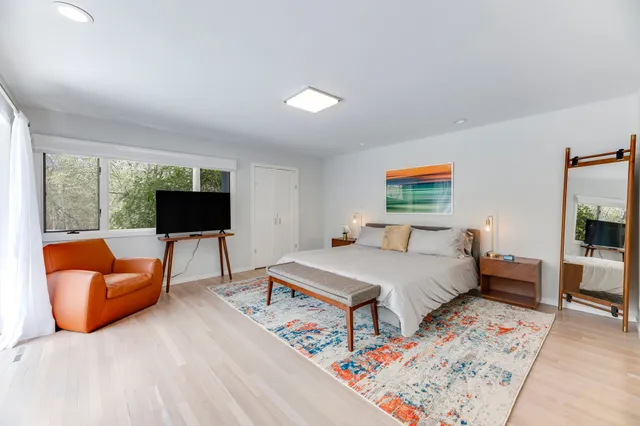 a bedroom with furniture and a flat screen tv