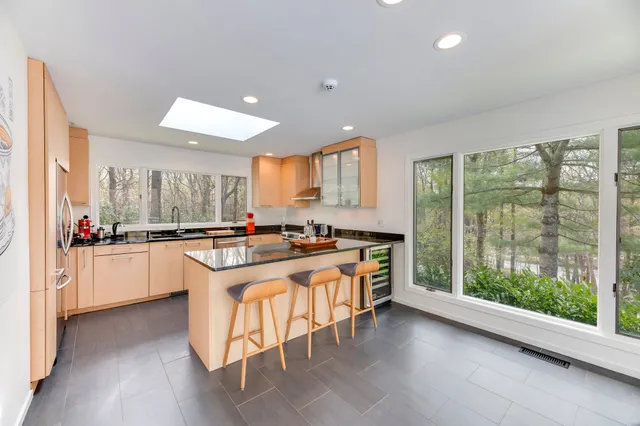 a kitchen with stainless steel appliances granite countertop a stove a sink dishwasher and a refrigerator with wooden floor