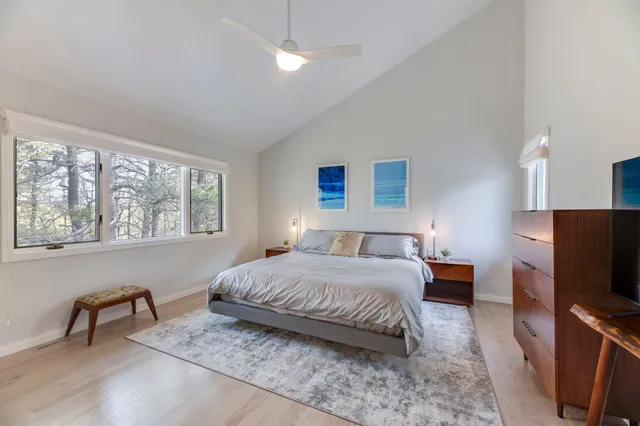 a bedroom with a bed tv and a window