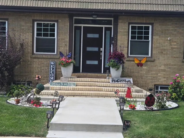 a front view of a house with a garden and plants