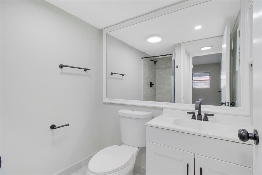 268 Saxony Circle, Unit 268 Delray Beach, FL 33446 - Photo 14 of 28 a bathroom with a sink toilet and mirror