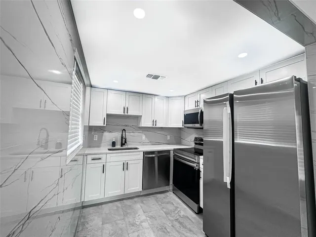 a kitchen with a sink stainless steel appliances and cabinets