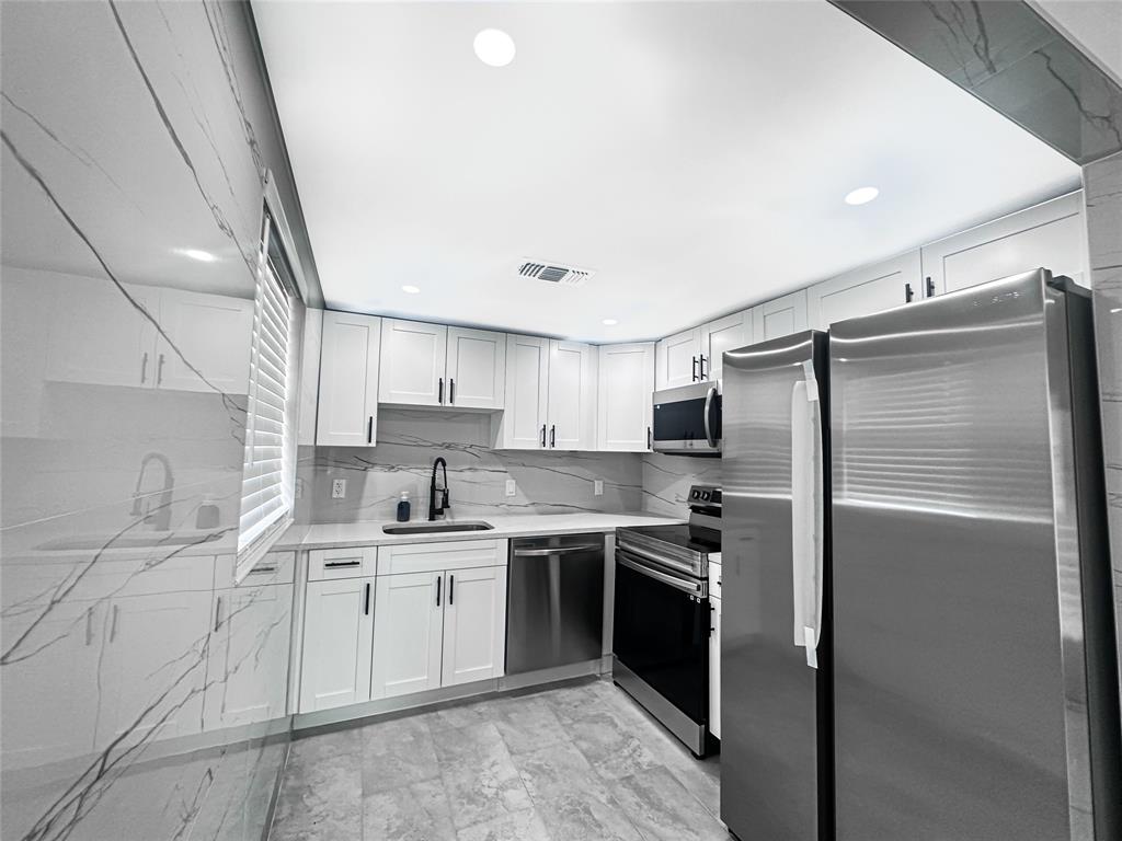 268 Saxony Circle, Unit 268 Delray Beach, FL 33446 - Photo 4 of 28 a kitchen with a sink stainless steel appliances and cabinets