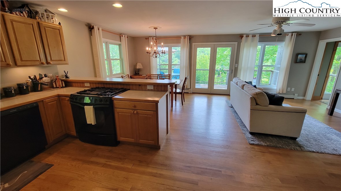 239 Wyndham Way Boone, NC 28607 - Photo 10 of 32 a kitchen with stainless steel appliances granite countertop a stove a sink dishwasher a refrigerator and a dining table with wooden floor