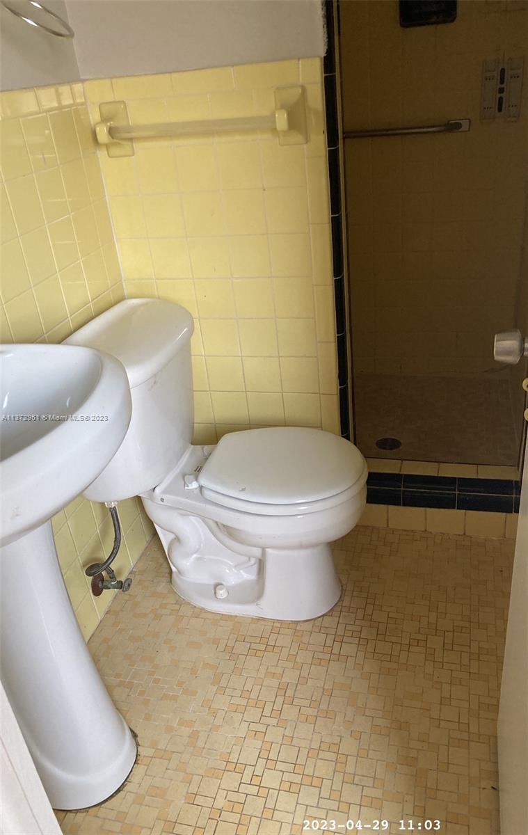 106 Engle Road Lake Worth, FL 33461 - Photo 6 of 10 a white toilet sitting next to a bathroom sink