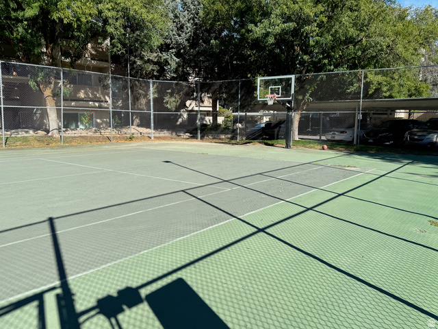985 Springcrest Court, Unit 11 Midvale, UT 84047 - Photo 27 of 27 Multi-sport court featuring a basketball hoop and tennis court lines, surrounded by chain-link fencing and mature trees