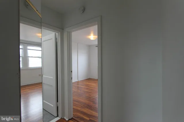 a view of hallway with closet and mirror