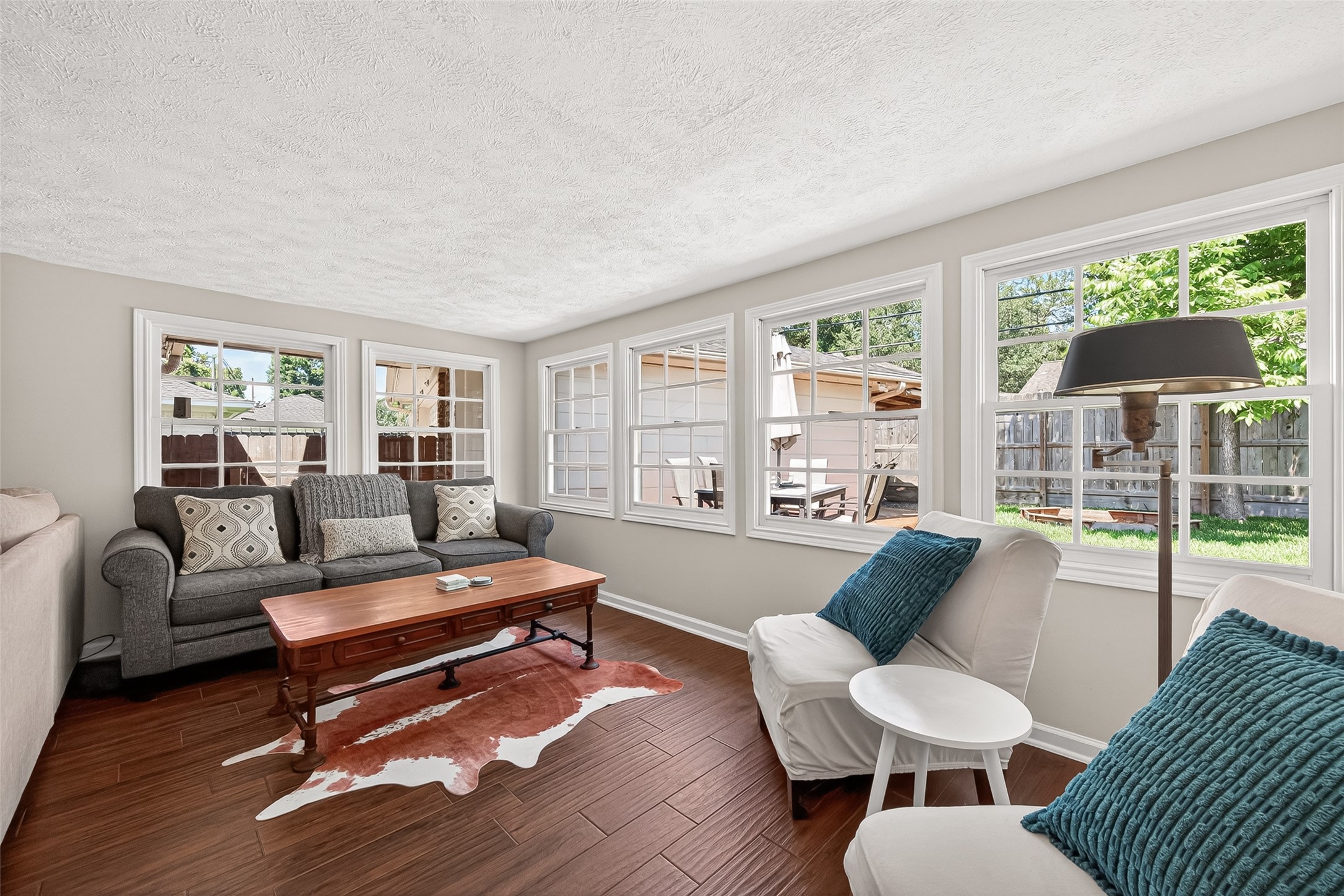 2610 Teague Road Houston, TX 77080 - Photo 17 of 49 Still part of the family room, this cozy sunroom area features large windows for ample natural light, warm flooring, and comfortable seating, offering a relaxing view of the backyard.