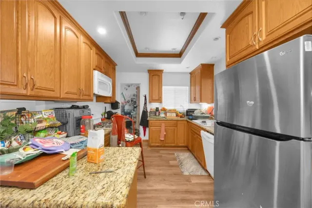 a kitchen with stainless steel appliances granite countertop a refrigerator a stove and a sink