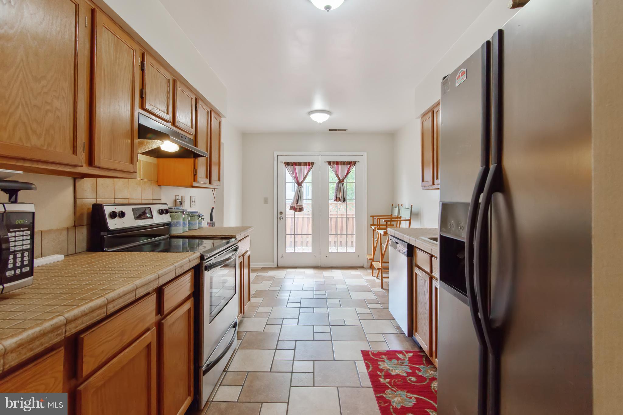 9304 Palmer Place, Unit 5 Laurel, MD 20708 - Photo 16 of 30 a kitchen with stainless steel appliances granite countertop a refrigerator a stove and a sink