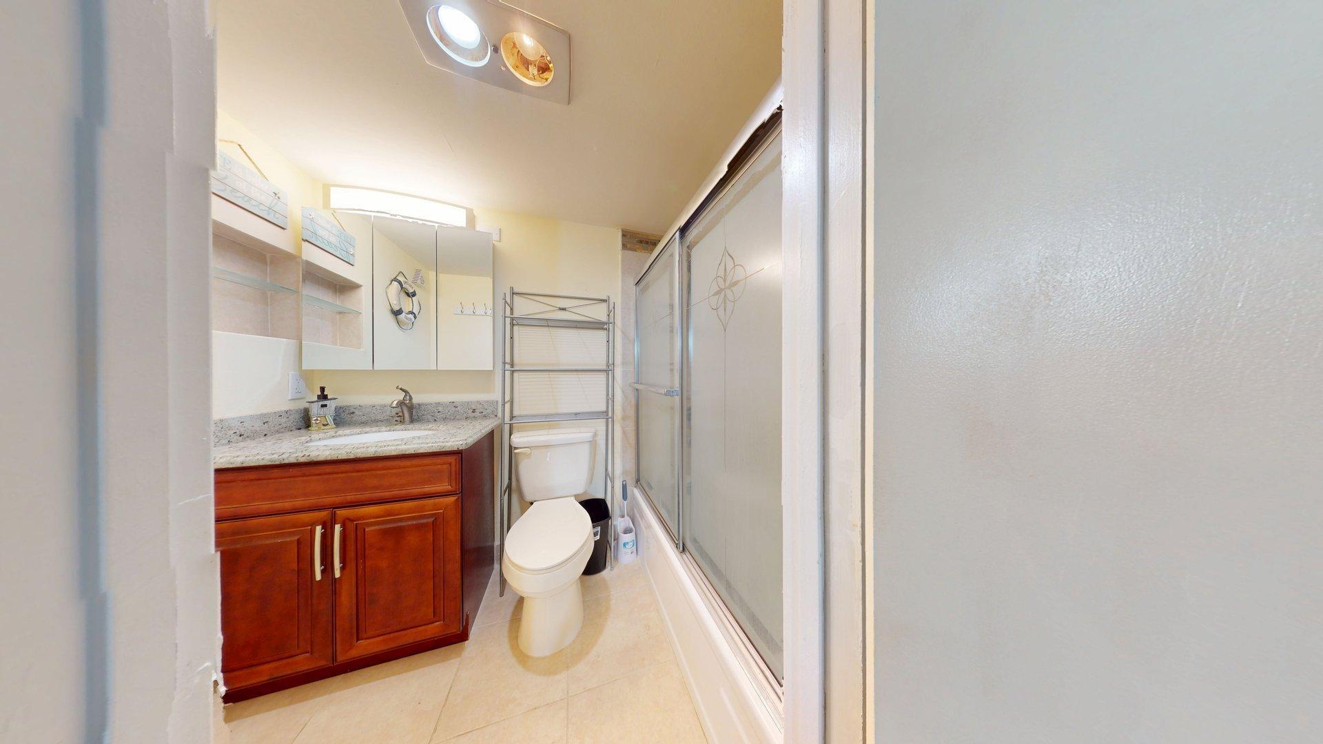 130 Dorchester East, Unit F West Palm Beach, FL 33417 - Photo 17 of 28 a bathroom with a sink a toilet and mirror