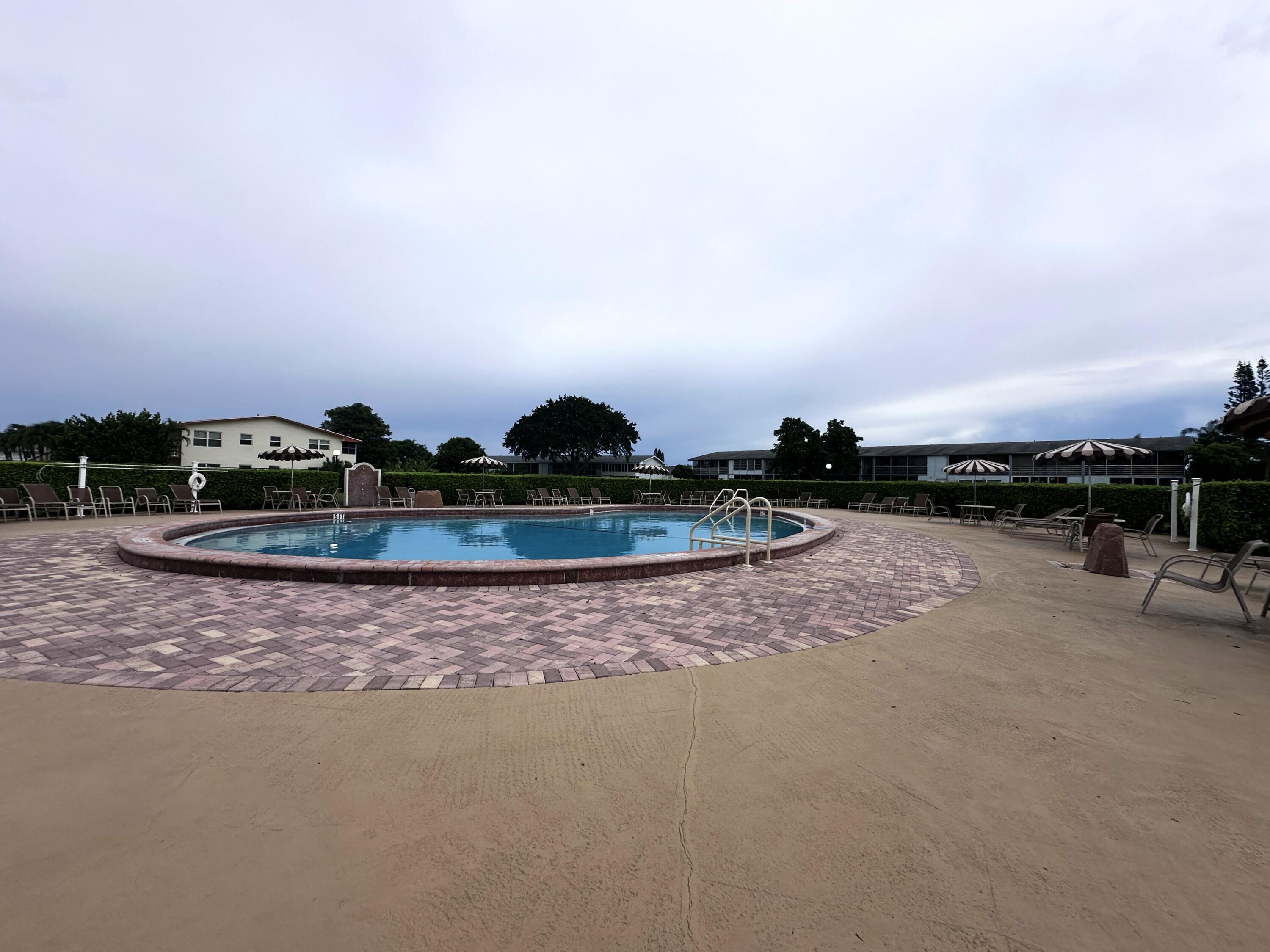 130 Dorchester East, Unit F West Palm Beach, FL 33417 - Photo 28 of 28 a view of swimming pool and lake view