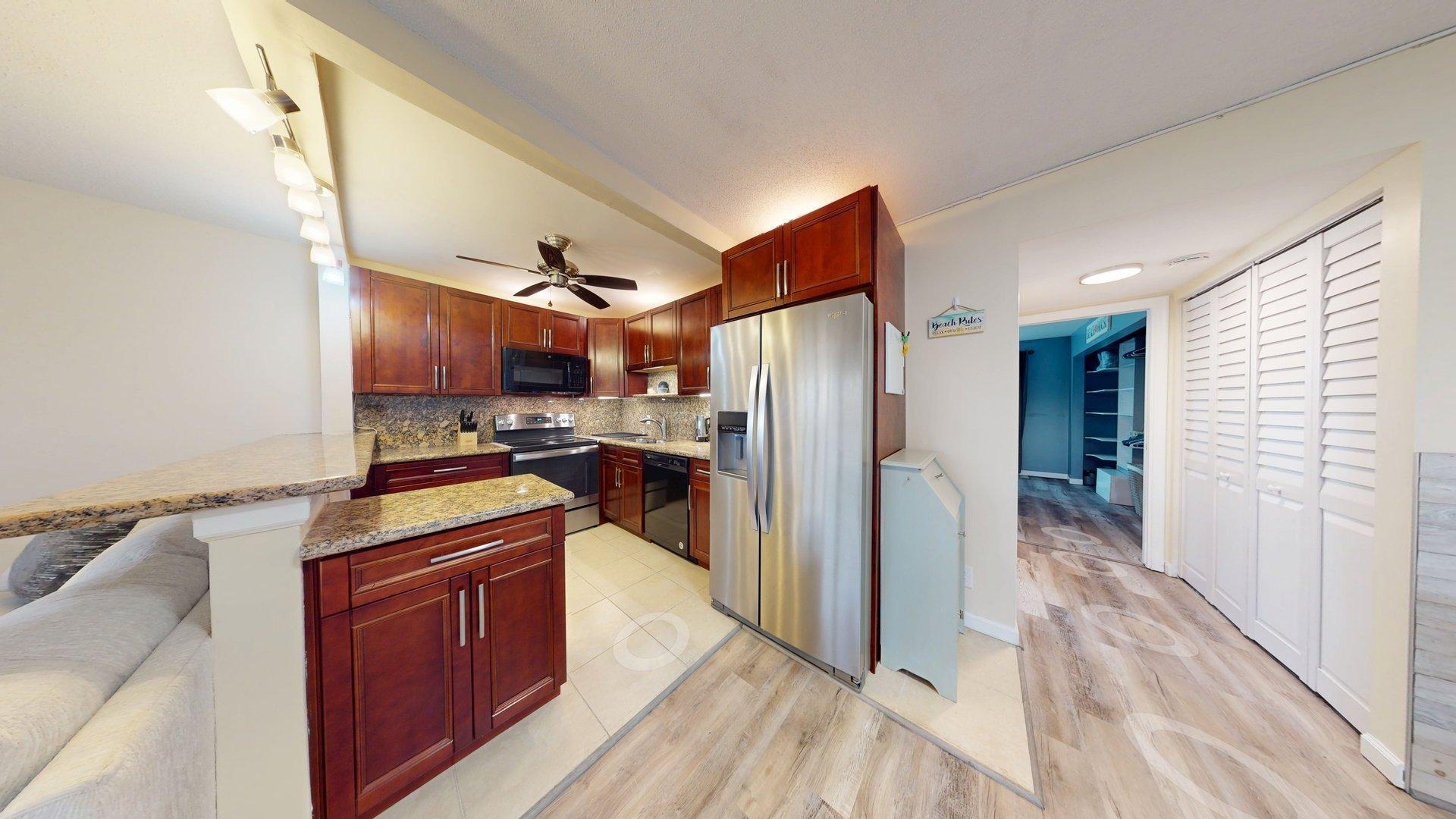 130 Dorchester East, Unit F West Palm Beach, FL 33417 - Photo 7 of 28 a kitchen with stainless steel appliances granite countertop a refrigerator and a stove