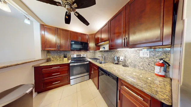 a kitchen with stainless steel appliances granite countertop a sink stove and refrigerator