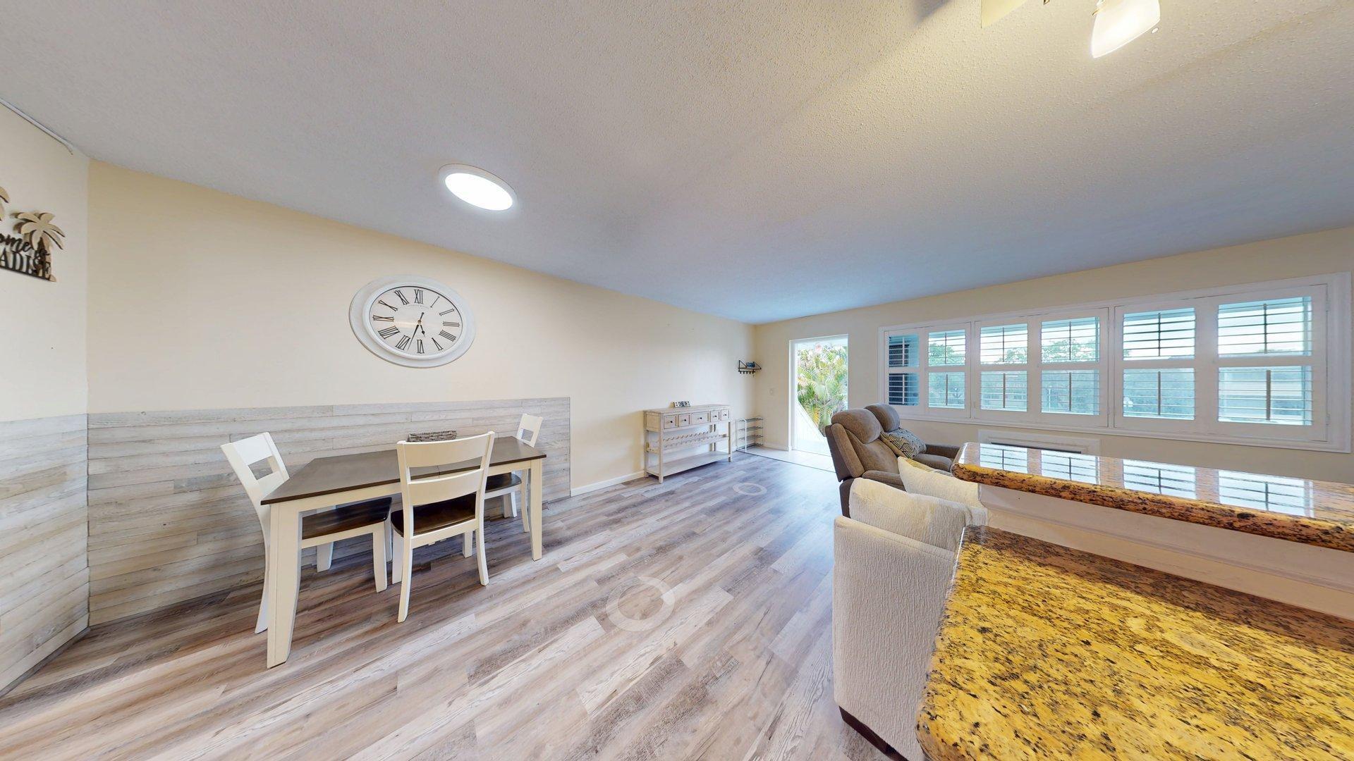 130 Dorchester East, Unit F West Palm Beach, FL 33417 - Photo 10 of 28 a dining room with furniture a chandelier and wooden floor