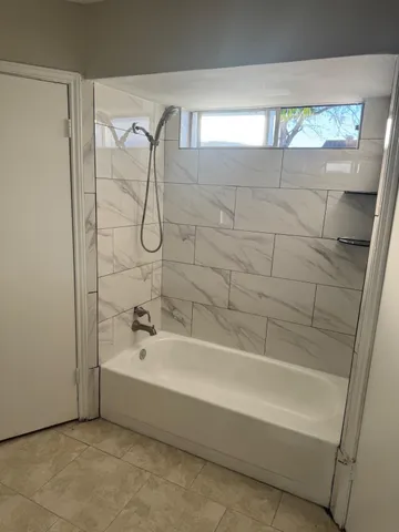 a bathroom with a bathtub and shower