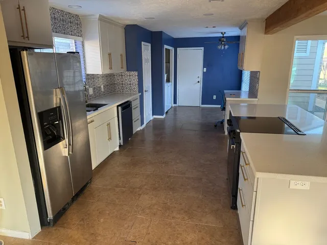 a kitchen with stainless steel appliances granite countertop a refrigerator a stove and a sink