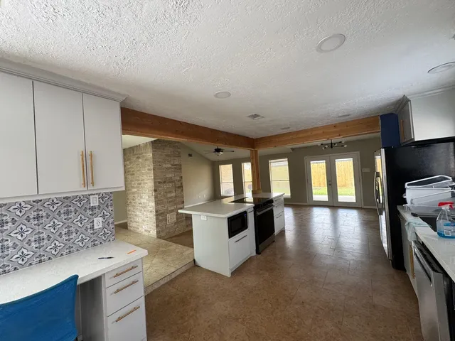 a kitchen with stainless steel appliances kitchen island granite countertop a stove and a sink