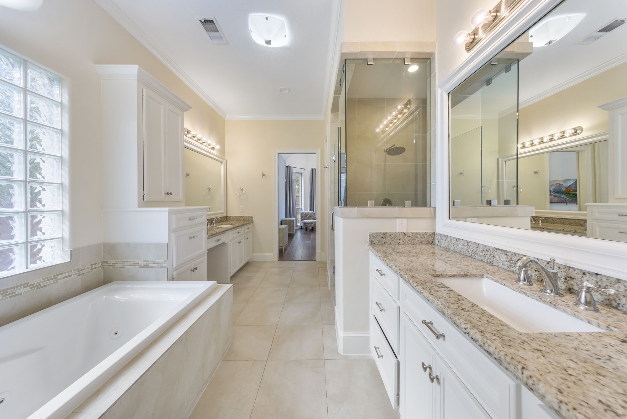 90 West Horizon Ridge Place Spring, TX 77381 - Photo 10 of 36 a spacious bathroom with a granite countertop double vanity sink a mirror and a bathtub