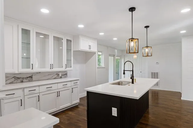 a kitchen with kitchen island a sink stainless steel appliances and cabinets