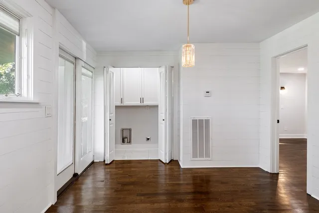 a view of empty room with wooden floor and window