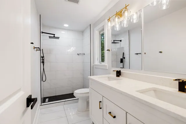 a bathroom with a sink a toilet and shower