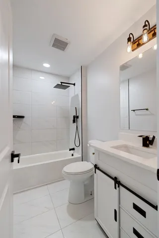 a bathroom with a granite countertop sink a toilet a mirror and shower