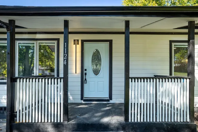 a view of a porch with a door and wooden floor