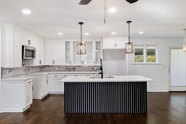 a kitchen with stainless steel appliances granite countertop wooden floor sink stove and wooden floor