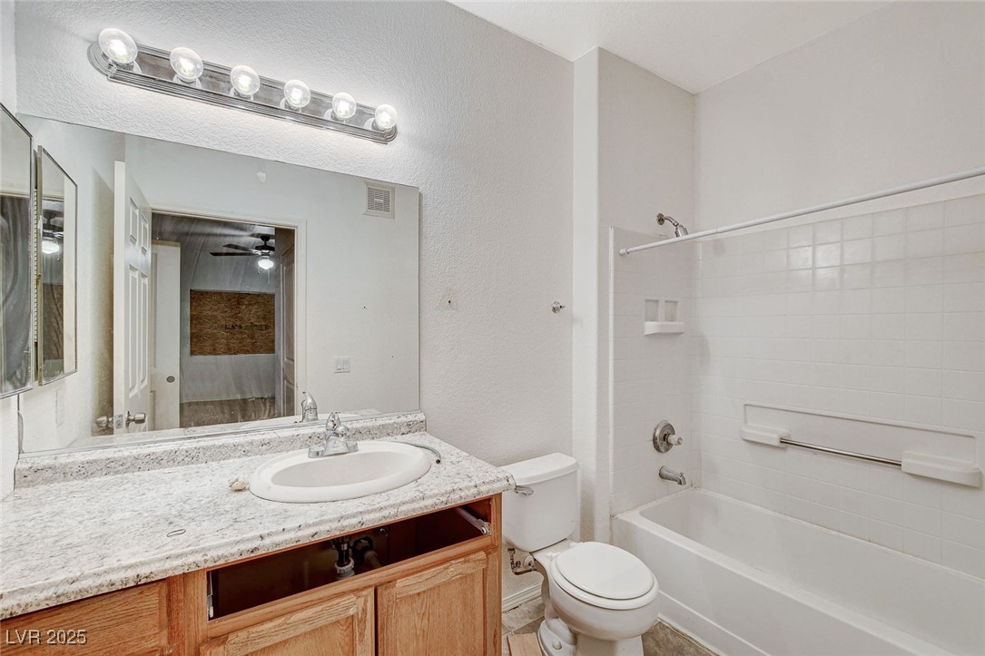 3318 North Decatur Boulevard, Unit 1061 Las Vegas, NV 89130 - Photo 20 of 49 Bathroom featuring bathing tub / shower combination, vanity, a textured wall, and a ceiling fan