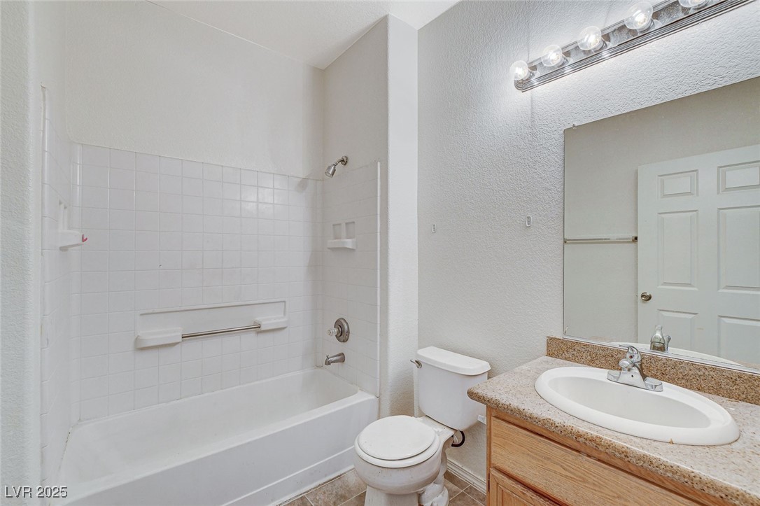 3318 North Decatur Boulevard, Unit 1061 Las Vegas, NV 89130 - Photo 24 of 49 Full bathroom with shower / bath combination, a textured wall, vanity, and light tile patterned flooring
