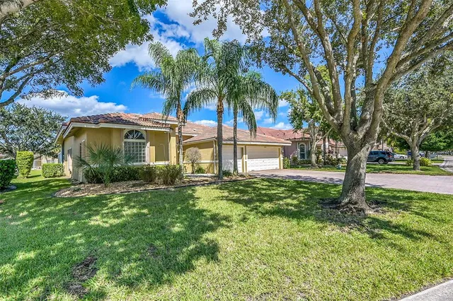 a view of a livingroom with a chandelier fan and windows