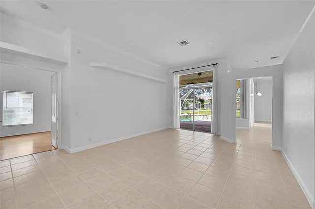 a view of an empty room with kitchen and kitchen view