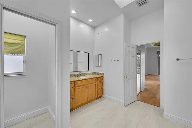 an empty room with a window and ceiling fan