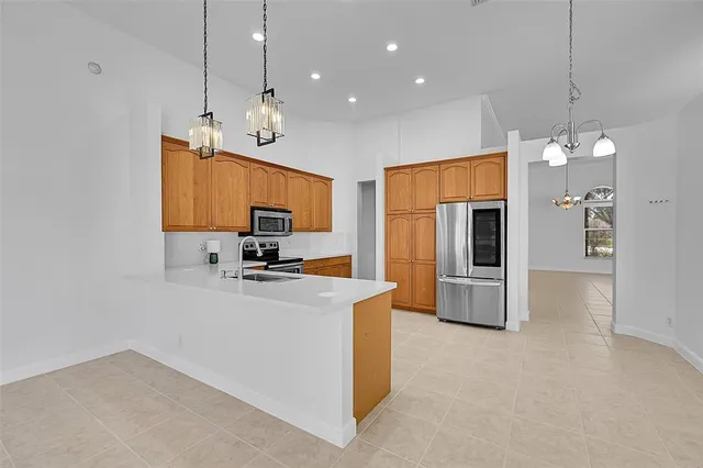 a kitchen with stainless steel appliances granite countertop a refrigerator a stove a sink and a microwave