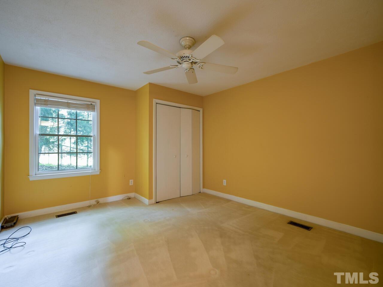115 Old Oxford Road Chapel Hill, NC 27514 - Photo 34 of 54 an empty room with a ceiling fan and windows