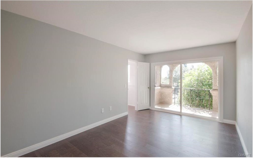 17824 Killion Street Encino, CA 91316 - Photo 12 of 25 an empty room with wooden floor and windows
