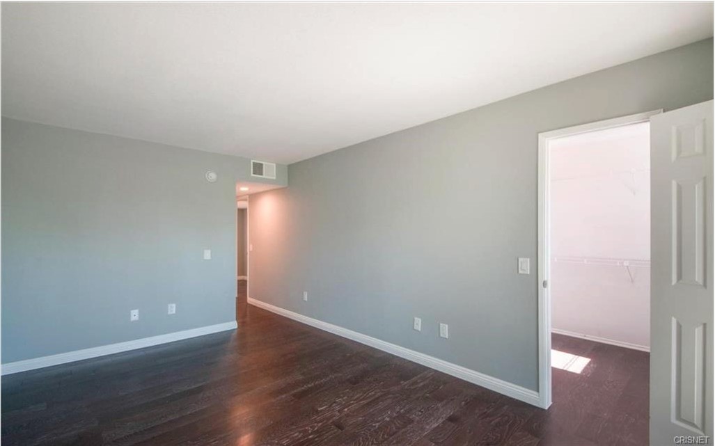 17824 Killion Street Encino, CA 91316 - Photo 15 of 25 an empty room with wooden floor and windows
