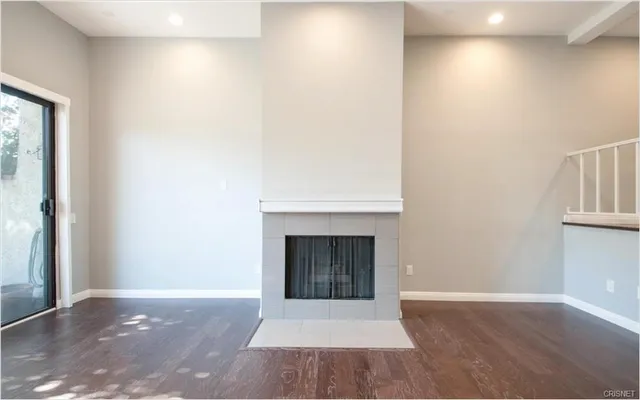 a view of an empty room with window and fire place