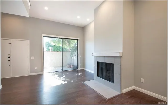 a view of a livingroom with wooden floor and a fireplace