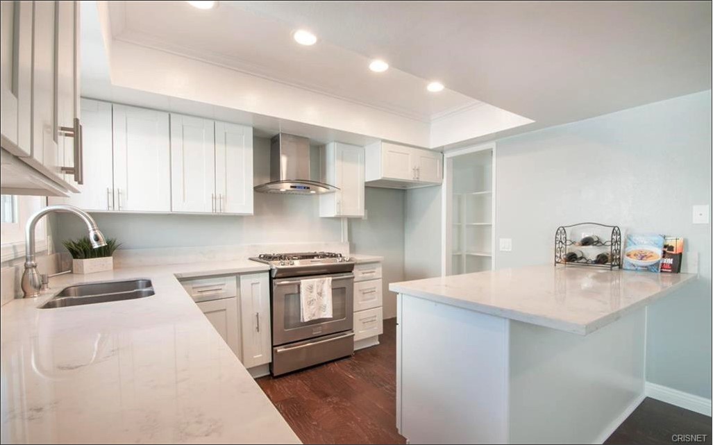 17824 Killion Street Encino, CA 91316 - Photo 8 of 25 a kitchen with stainless steel appliances granite countertop a sink stove and refrigerator