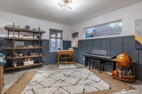 a living room with furniture a piano and a bookshelf