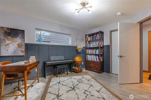 a living room with furniture a piano and a bookshelf
