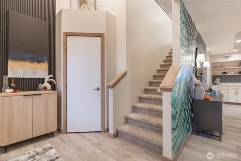 a view of hallway with stairs and wooden floor